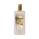 Frosted light pink rectangular perfume bottle with a gold-toned cap and an illustrated label depicting a golden cityscape wit