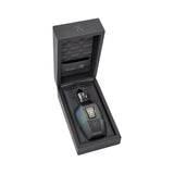 Black textured box with a dark multi-faceted perfume bottle. Bottle has a blue-green to black gradient, gold-toned cap, and L