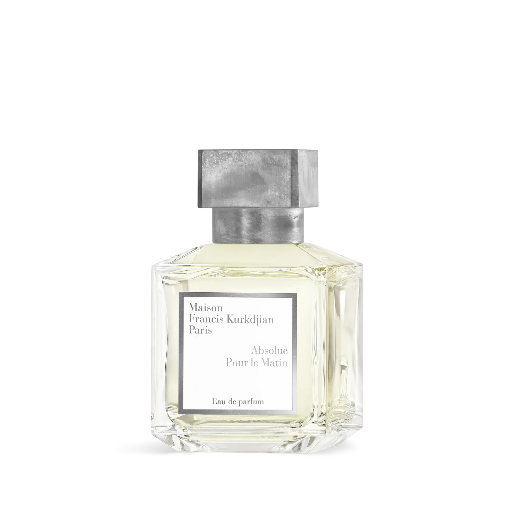 Clear faceted glass perfume bottle with light yellow liquid, a white label, and a textured silver-toned rectangular cap.