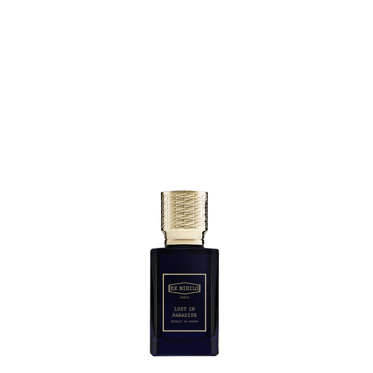 A luxury bottle of Ex Nihilo Lust in Paradise Extrait de Parfum. The rectangular bottle is made of deep midnight-blue transparent glass with a gold-bordered label featuring the brand and fragrance name in gold typography. It is topped with a heavy, intricately textured gold cap, set against a seamless white background.