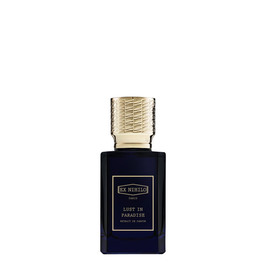 A luxury bottle of Ex Nihilo Lust in Paradise Extrait de Parfum. The rectangular bottle is made of deep midnight-blue transparent glass with a gold-bordered label featuring the brand and fragrance name in gold typography. It is topped with a heavy, intricately textured gold cap, set against a seamless white background.