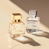 Clear rectangular glass perfume bottle with a silver-toned square cap and a white label.
