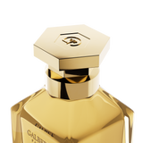 A close-up detail shot of the golden hexagonal cap on the Galbee Paris bottle, showcasing the delicate bee engraving on the top surface.