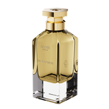 A three-quarter perspective view of the Galbee Paris Galbee Is Woody perfume bottle, showing its clear glass base, amber interior, and hexagonal gold cap.