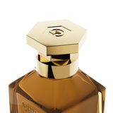 A close-up detail shot of the golden hexagonal cap on the Galbee Paris bottle, showcasing the delicate bee engraving on the top surface.