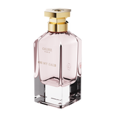 A three-quarter perspective view of the Oh My Galb perfume bottle, showing its clear glass base, soft pink interior, and hexagonal gold cap.