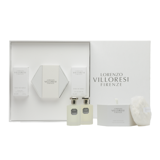 A luxury white gift set from Lorenzo Villoresi Firenze containing Teint de Neige Eau de Parfum, Hair Mist, and Scented Body Powder with a white fluffy puff, all arranged in a premium white presentation box.