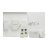A luxury white gift set from Lorenzo Villoresi Firenze containing Teint de Neige Eau de Parfum, Hair Mist, and Scented Body Powder with a white fluffy puff, all arranged in a premium white presentation box.