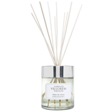 A luxury room fragrance set by Lorenzo Villoresi Firenze. The image features a clear glass diffuser jar filled with pale liquid and several natural wood reeds fanning out from a polished silver collar. The jar label and the accompanying minimalist white presentation box both feature the brand name and "TEINT DE NEIGE ROOM FRAGRANCE" in elegant black typography.