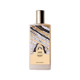 A white bottle of Memo Paris Zante Eau de Parfum standing next to its tan textured presentation box. The bottle features a colorful, abstract illustration of coastal rock formations.