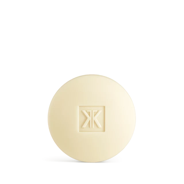 A round, cream-colored bar of Maison Francis Kurkdjian 724 scented soap featuring the brand's monogram logo embossed in the center.