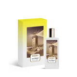 A luxury perfume set featuring the Memo Paris Cap Camarat Eau de Parfum bottle and its presentation box. The rectangular frosted white bottle has a gold cap and a central illustration of a lighthouse shining its light over rocky waves. The box matches the artwork with a vibrant yellow-to-white gradient background, emphasizing the premium "Fleurs Bohèmes" collection branding.