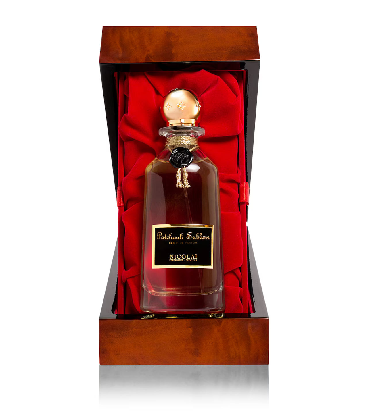 The Patchouli Sublime carafe presented inside an opened, high-gloss lacquered wooden case with a plush red velvet interior.