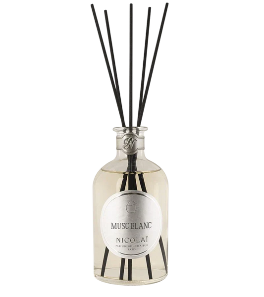 Nicolai Musc Blanc diffuser bottle with black reeds on a white background.