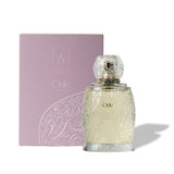 Artist’O Ode Eau de Parfum in an ornate clear glass bottle with a soft ivory fragrance, displayed with pastel pink luxury packaging – Find Online Today