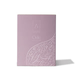 Artist’O Ode Eau de Parfum in an ornate clear glass bottle with a soft ivory fragrance, displayed with pastel pink luxury packaging – Find Online Today