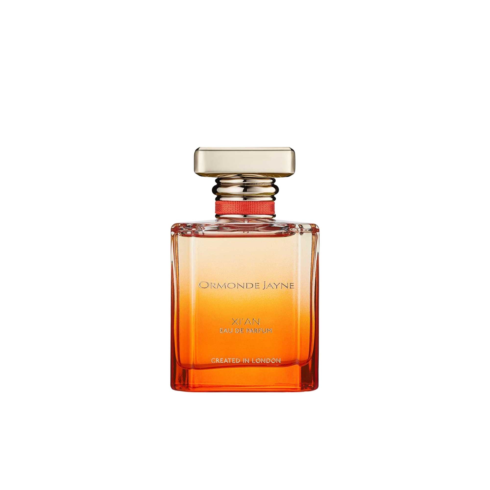 A 50ml bottle of Ormonde Jayne Xi'an Eau de Parfum. The rectangular glass bottle features a warm orange gradient, a gold cap with a red ribbon collar, and gold lettering.