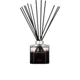 A 500ml Ormonde Jayne luxury reed diffuser featuring a square clear glass bottle filled with dark liquid, a silver collar, and a fanned-out arrangement of black reeds.