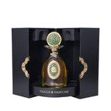 Amber perfume bottle with gold-toned cap and green mosaic details. In open black box with gold-toned wavy handles.