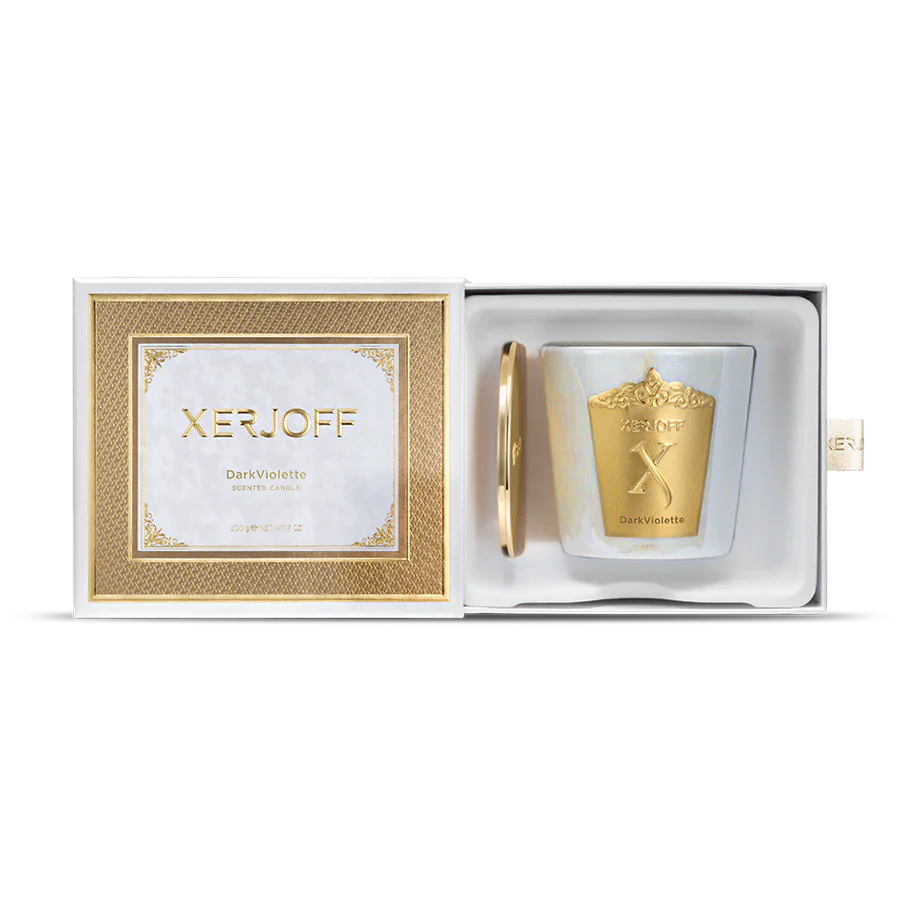 A close-up of the Dark Violette scented candle in a tapered purple glass holder, featuring an intricate gold star-patterned label and the embossed Xerjoff "X" logo.